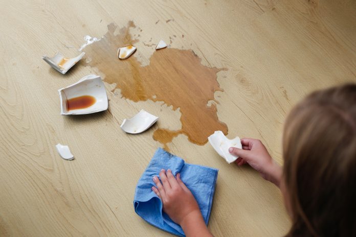 A broken cup of coffee fell on laminate, coffee spilled on floor